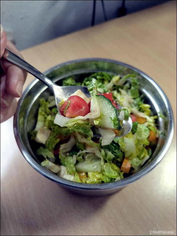 Schüssel mit buntem Salat, Hand mit Löffel, darauf Salat. Für die Aktion Zwölf von Zwölf im Juli