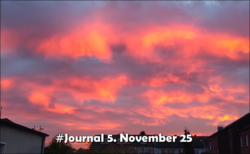 Sonnenaufgang. Rosa-Orange angestrahlte Wolken über Häuserdächern, unten zentriert der Schriftzug "#Journal 5. November 25"